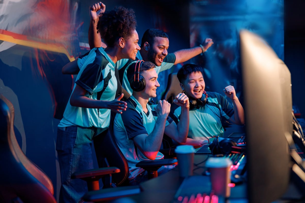 Players celebrating and raising their hands during a gaming tournament