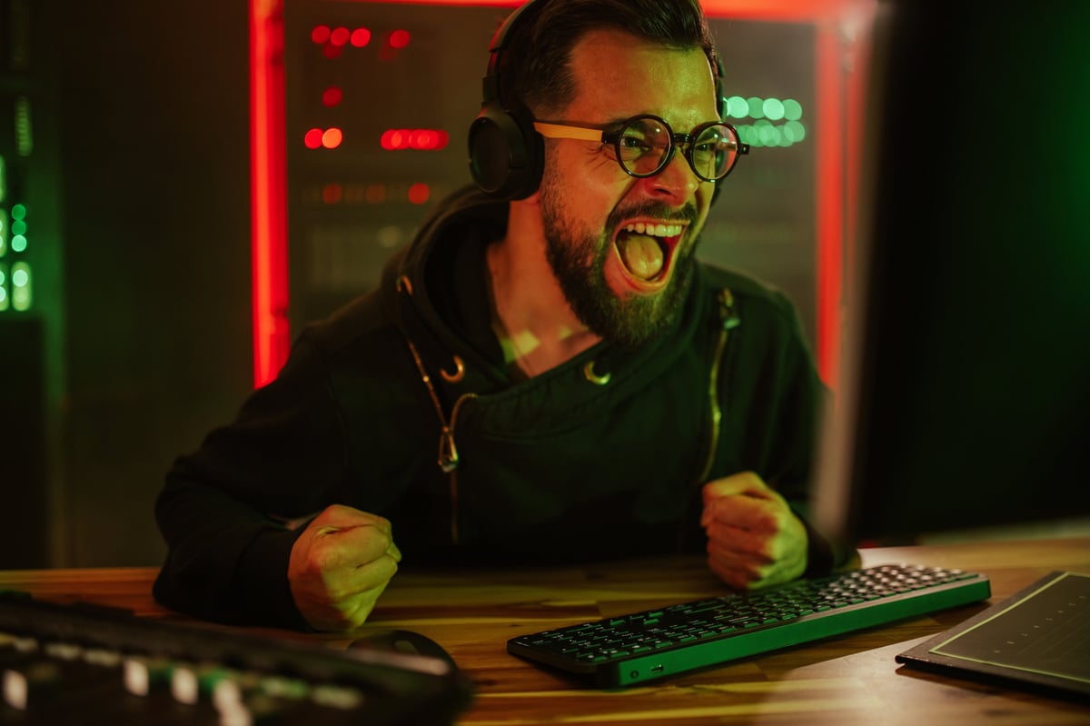 Gamer celebrating a victory enthusiastically at a computer